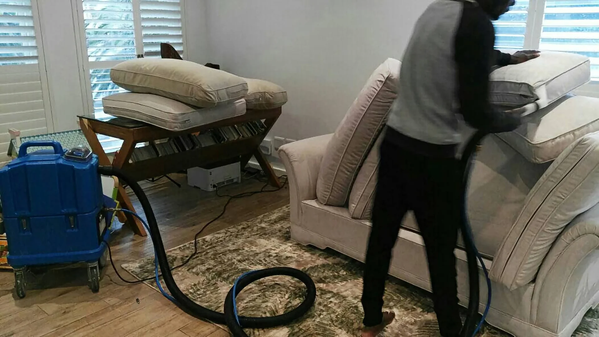 Technician spraying pest treatment around a property perimeter